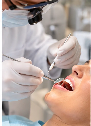 Exame odontológico com espelho clínico e sonda, em close do sorriso da paciente